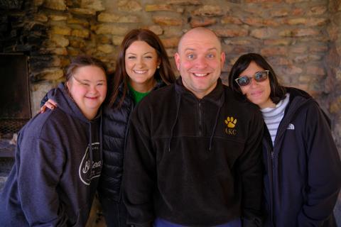 four adult friends smiling posing for a picture
