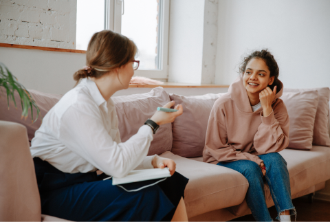 a woman is counseling another young girl on a couch