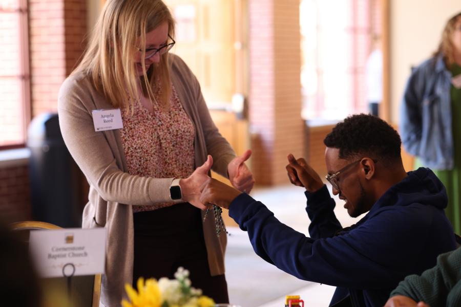 photo of Angela Reed and a B2B participant exchanging a new kind of handshake
