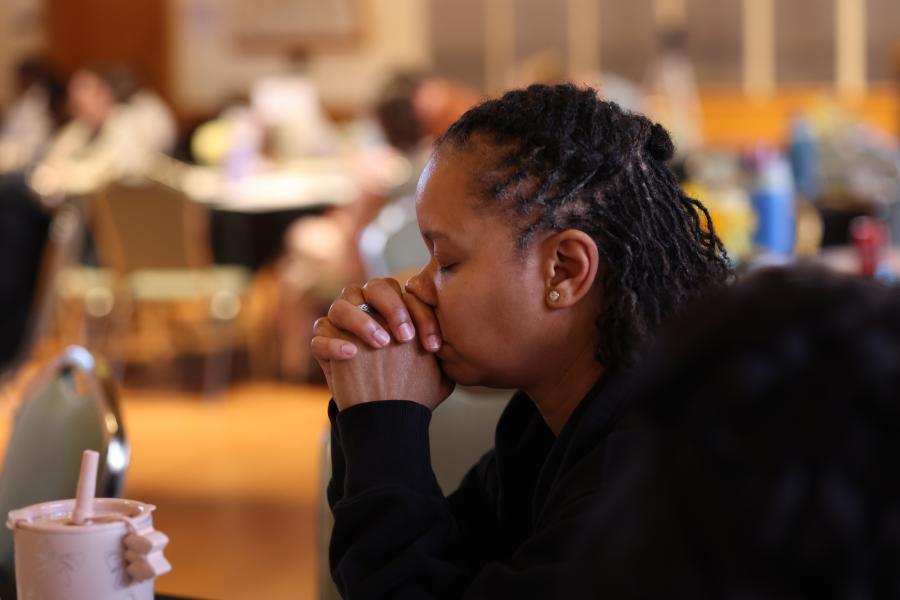 Photo of a person praying with eyes closed at the B2B gathering