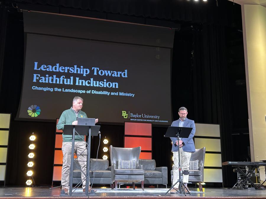 Photo of Erik Carter and Jason Le Shana presenting on the main stage at the 2026 DATC conference in Washington, D.C.
