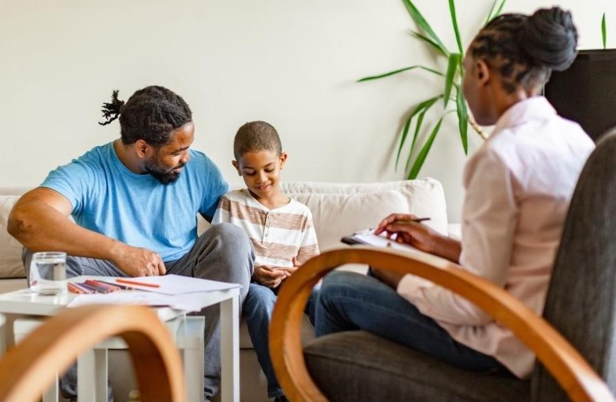 Photo of father with young son at a counseling session with a licensed psychologist.